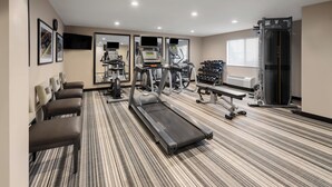 Ein Fitnessraum mit Laufbändern, Ergometer und Kurzhanteln.