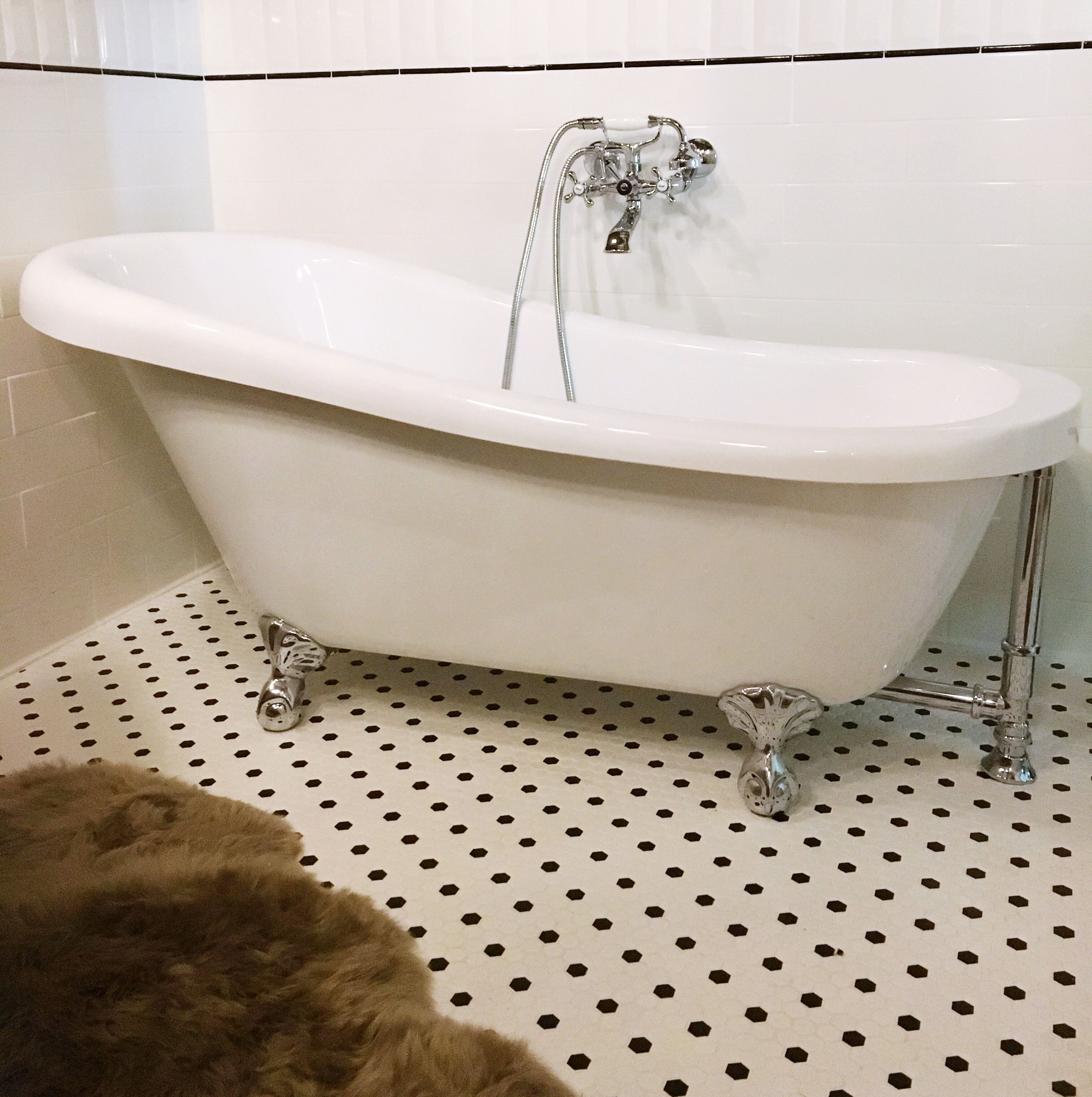 A white freestanding bathtub with a single faucet and no visible controls.