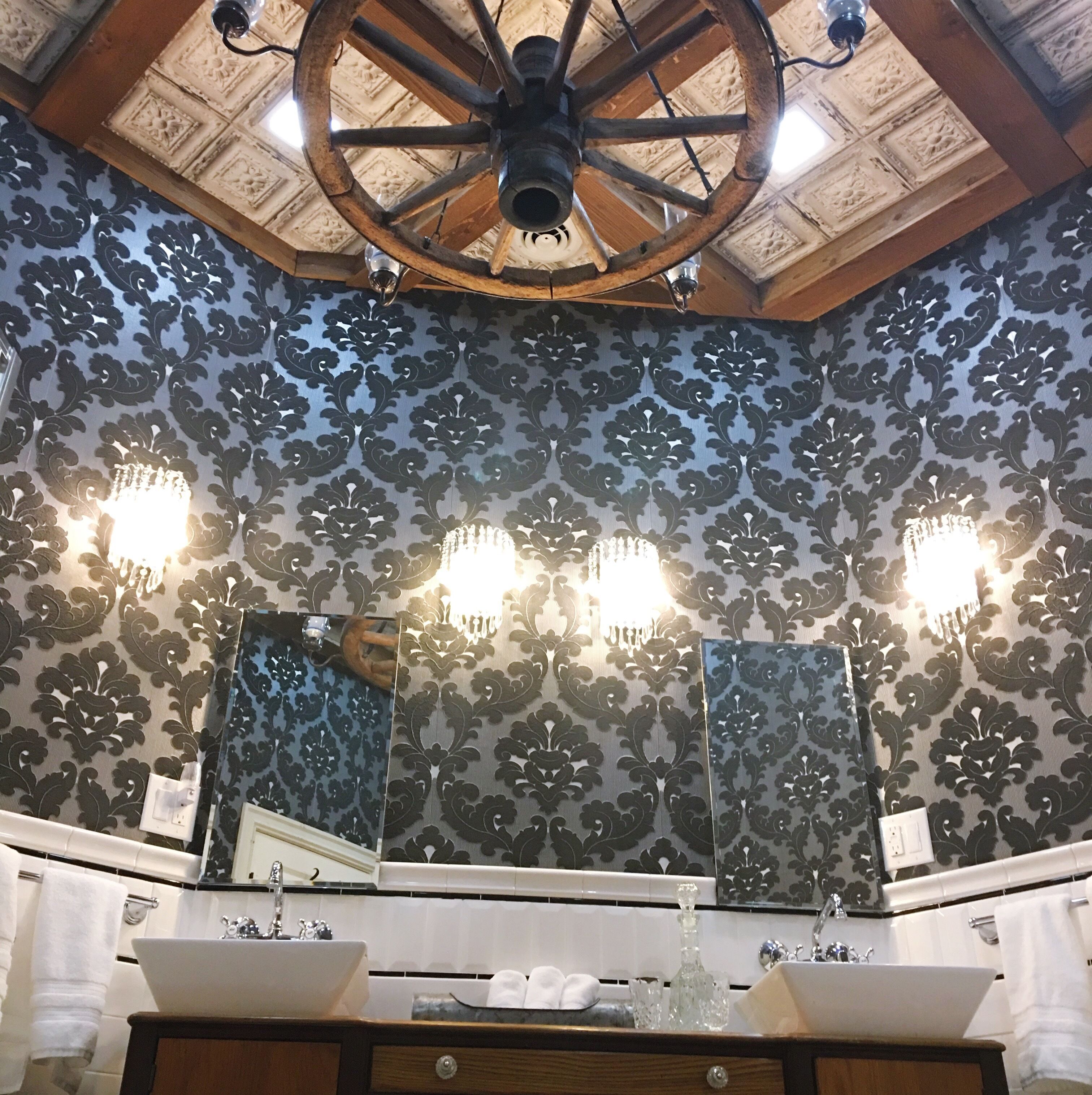 A bathroom with a large mirror, two sinks, and a ceiling fan.