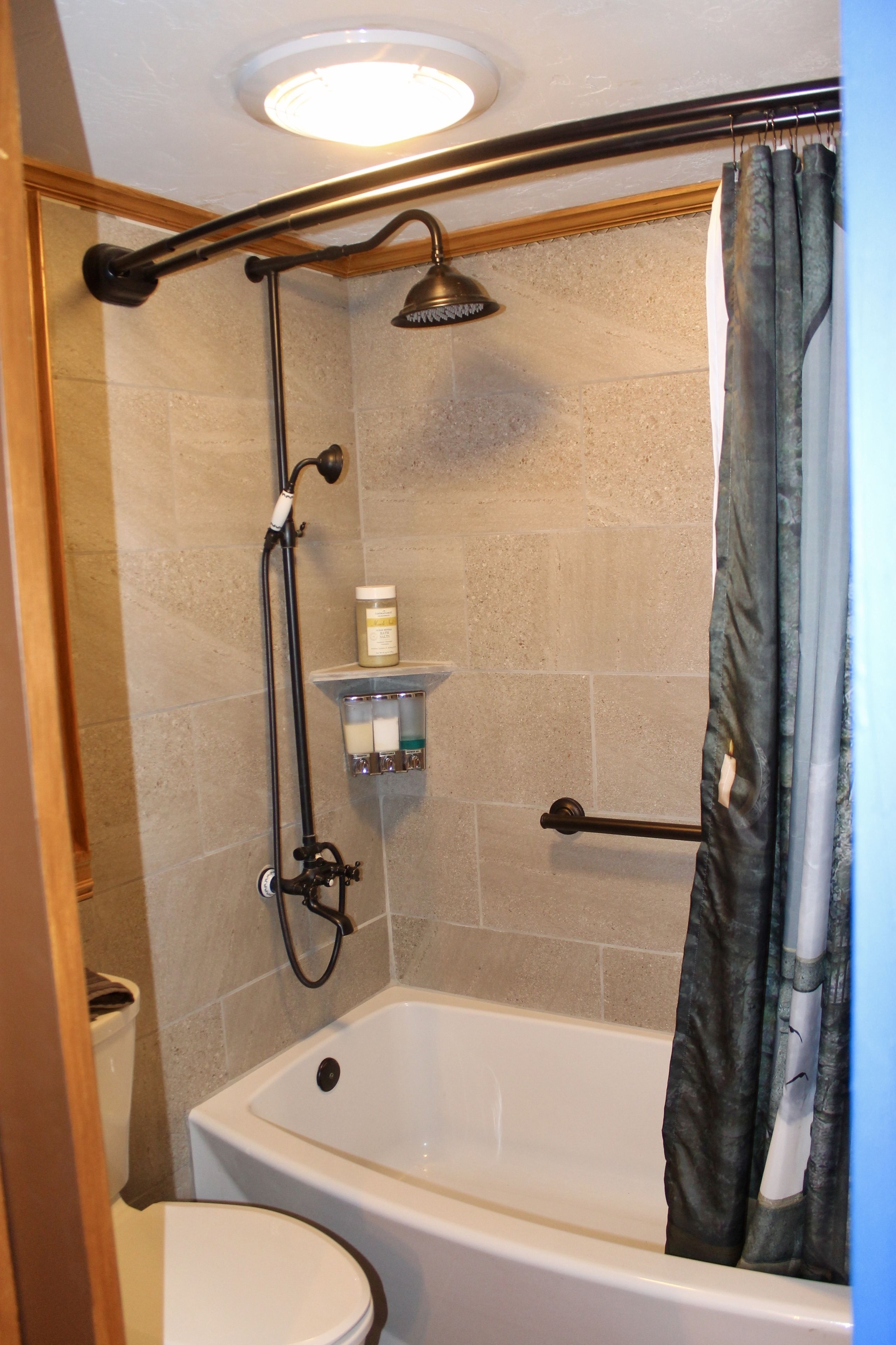 A bathroom with a bathtub, shower, and toilet.