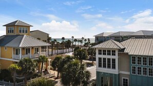 A coastal residential area with multiple houses, some with balconies, and a view of the ocean. - The Love Shack (Panama City Beach)