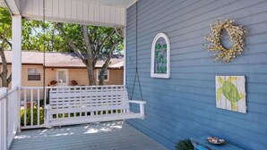 Un portico con un'altalena bianca, un muro blu e una decorazione a tema tartaruga.