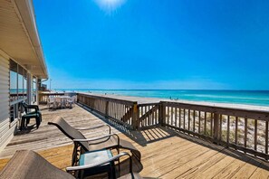 A wooden deck with outdoor seating overlooking a beach. - Barefoot Beach Retreat 3 Bedroom Apartment (Panama City Beach)