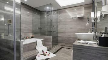 Un baño moderno con ducha de vidrio, bañera independiente y un amplio lavamanos.