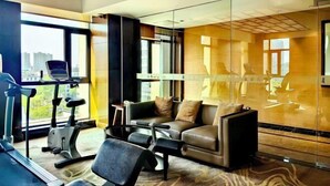 A modern hotel room with a treadmill, a sofa, and a glass partition. - Jiangyin Furen Boutique Hotel (Zhongshan Park Subway Station) (Jiangyin)