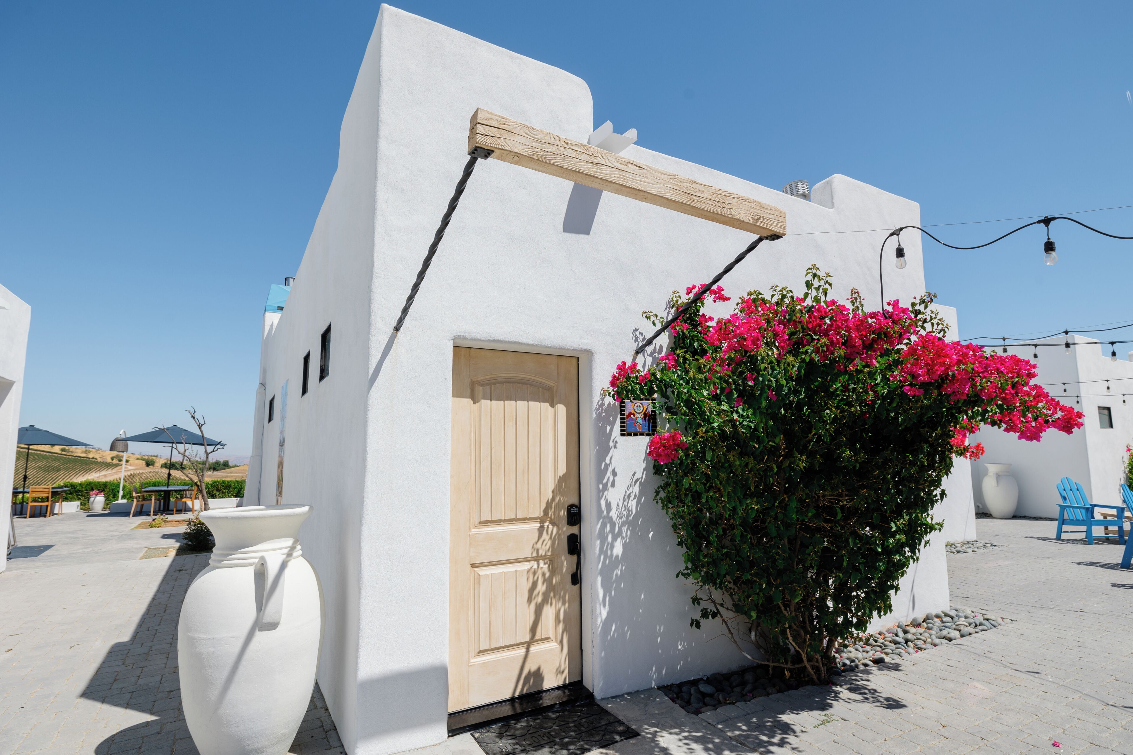 Un edificio blanco con puerta de madera y un pequeño porche.