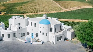 A modern white building with a blue dome, surrounded by green fields and a paved area. - Sirena Resort (Paso Robles)