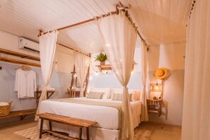 Een knus slaapkamer met een hemelbed, een nachtkastje, een hangplant en een hoed aan de muur.