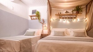 Une chambre avec deux lits, un banc en bois et des guirlandes lumineuses.