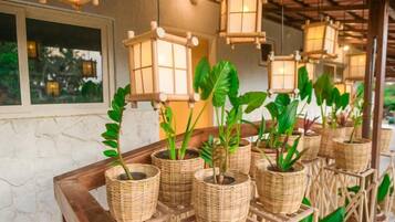 Wicker planters with green plants on a wooden table.