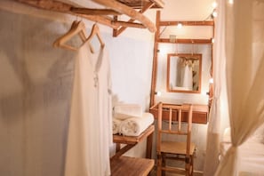 A wooden vanity with a mirror, lights, and a towel rack.