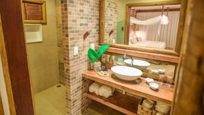 Une salle de bain avec un meuble-lavabo en bois, deux vasques, un miroir et un luminaire suspendu.