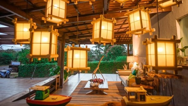 A traditional Japanese-style room with tatami flooring, low wooden tables, and hanging paper lanterns. - Ecocharme Pousada Do Marcilio (Fernando de Noronha)
