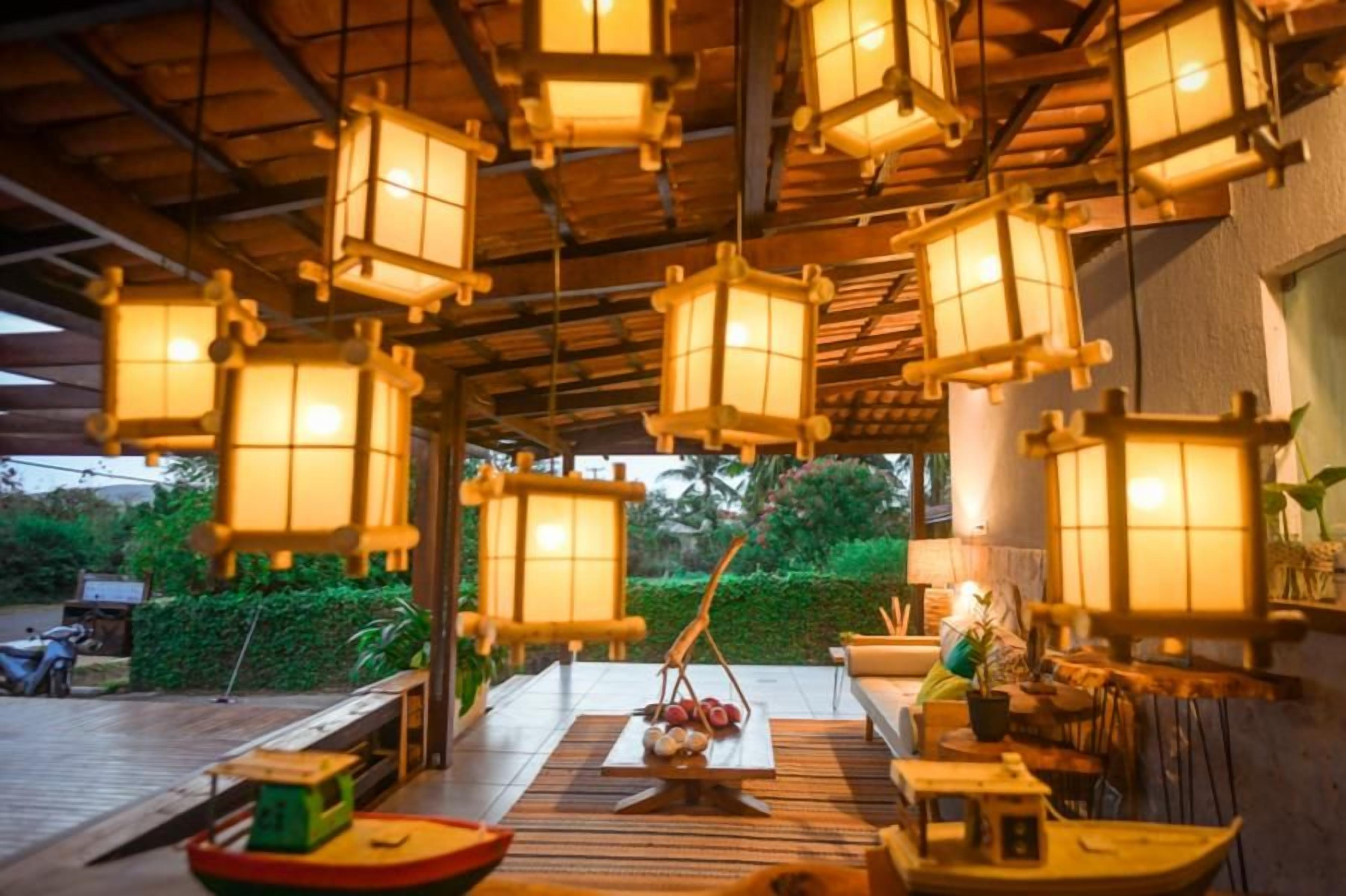 A traditional Japanese-style room with tatami flooring, low wooden tables, and hanging paper lanterns.