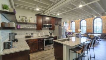 A modern kitchen with dark wood cabinets, stainless steel appliances, and a large island with bar stools.