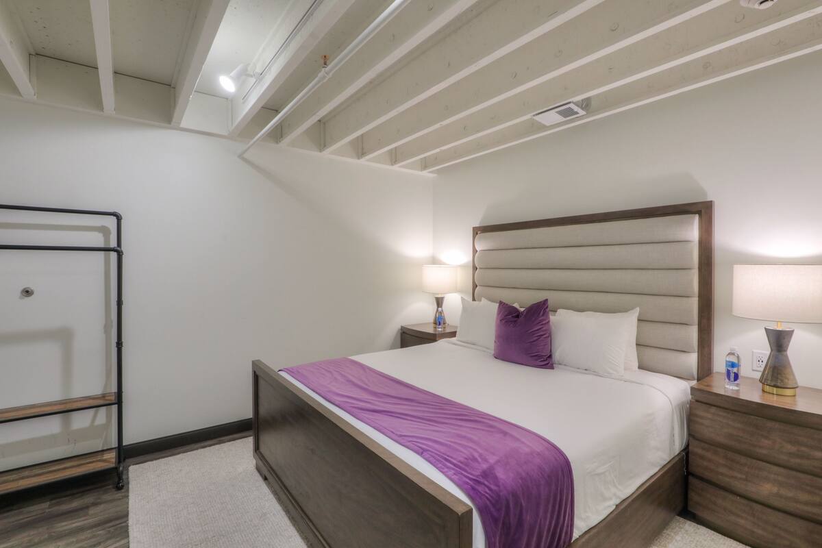 A bedroom with a bed, nightstands, a lamp, and a ceiling fan.