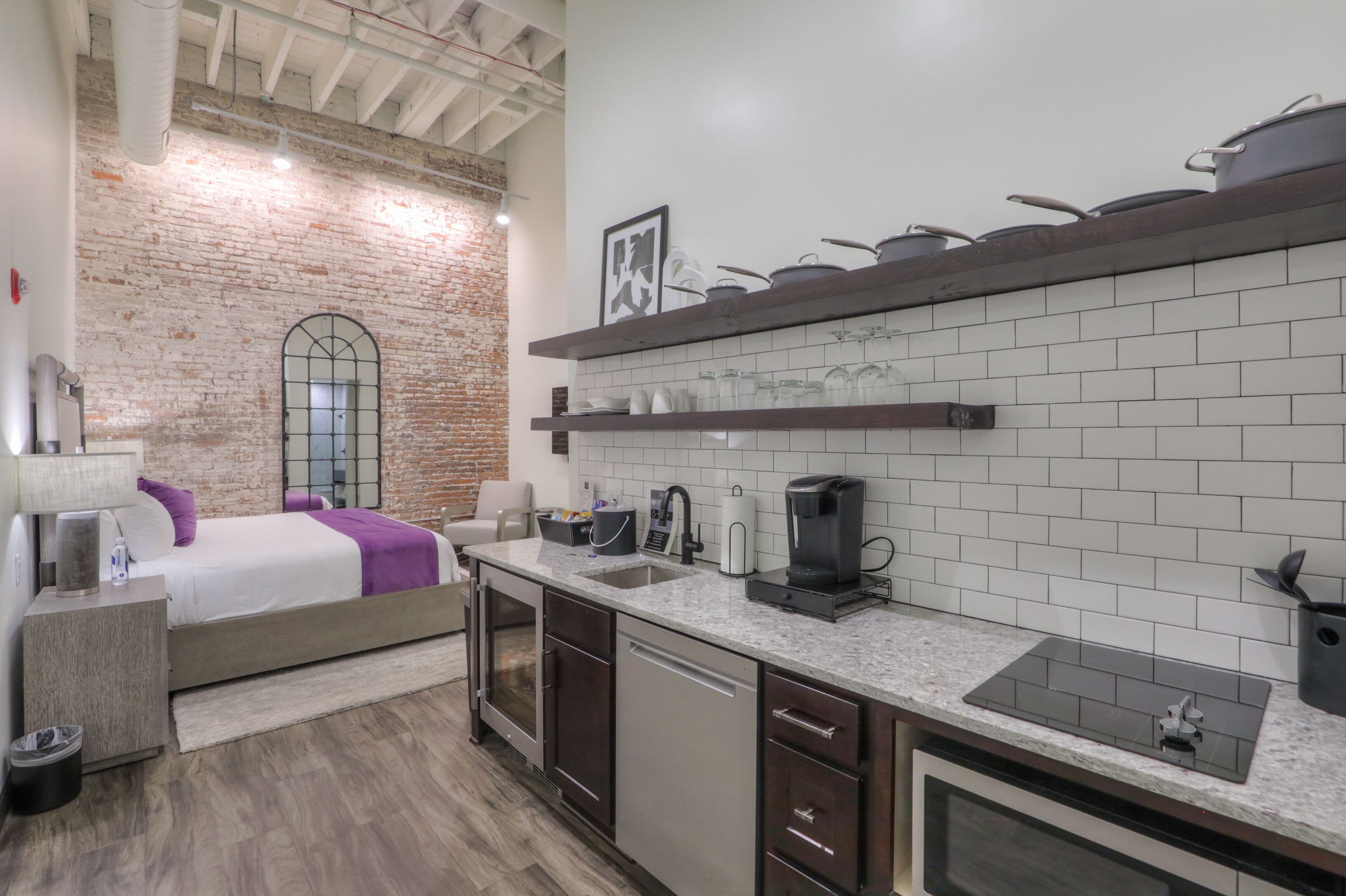 Una cocina moderna con pared de ladrillo, un ventanal grande y un horno empotrado.