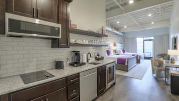 A modern kitchen with dark wood cabinets, a stainless steel microwave, and a built-in dishwasher.