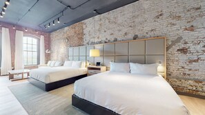 A hotel room with two beds, a brick wall, and a large window. - Studio 154 Luxury Hotel (Nashville)