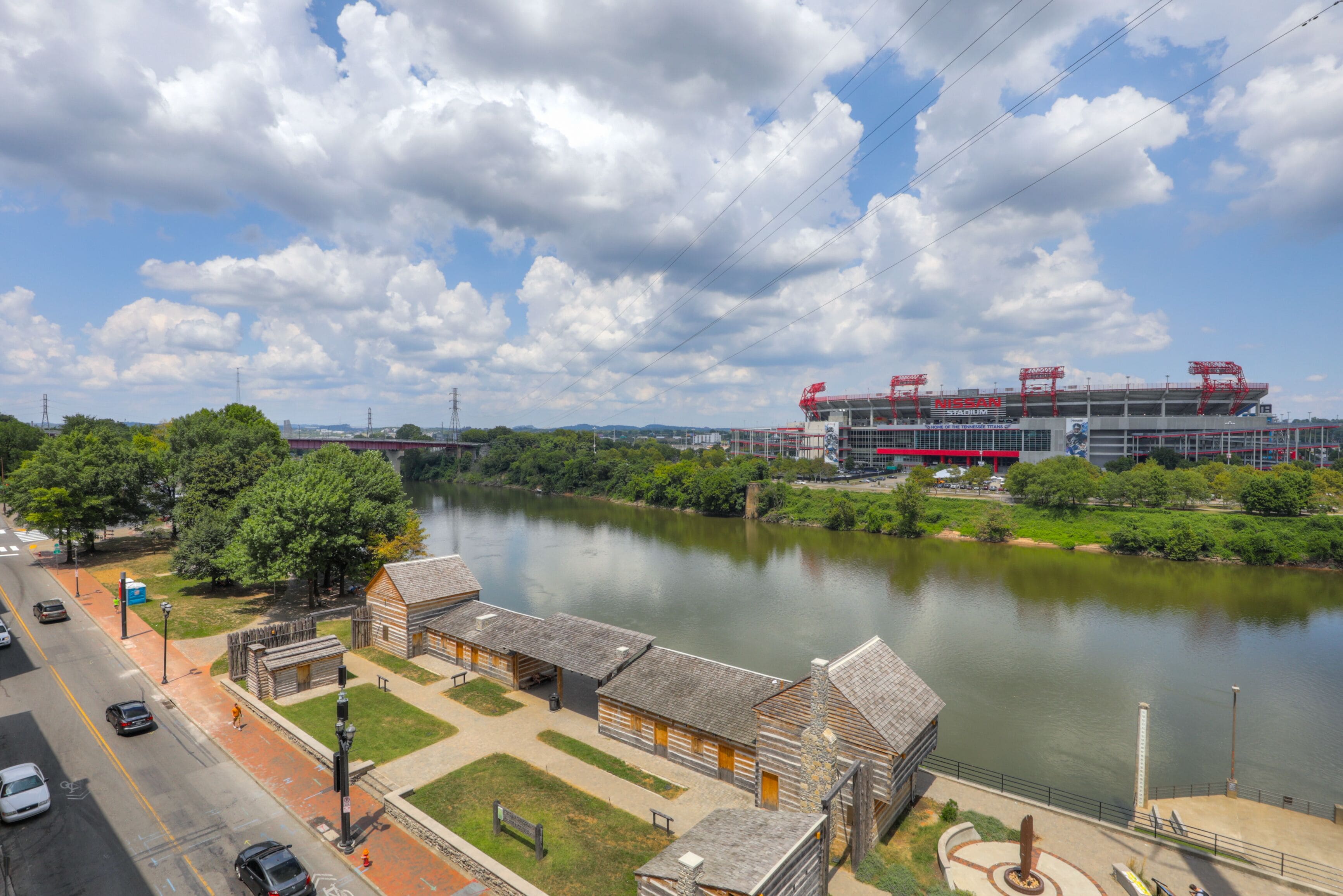 Une vue sur le fleuve, avec un bâtiment historique et un stade en arrière-plan.