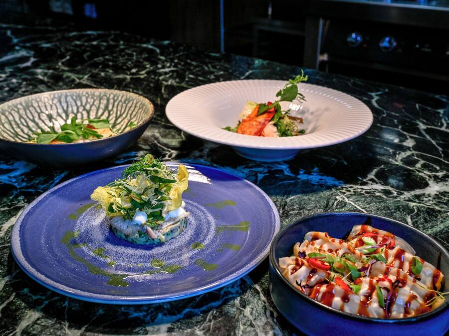 Three bowls of food on a marble countertop.