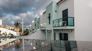 A modern building with a glass balcony, a staircase, and a clear sky. - Mediterranean Villas (Santa Cruz)