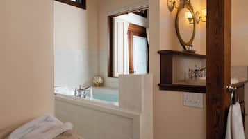 A bathroom with a bathtub, a mirror, a towel rack, and a light fixture.