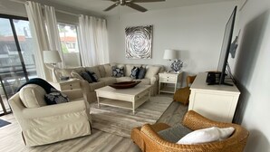 A modern living room with a sofa, coffee table, and wicker chair.
