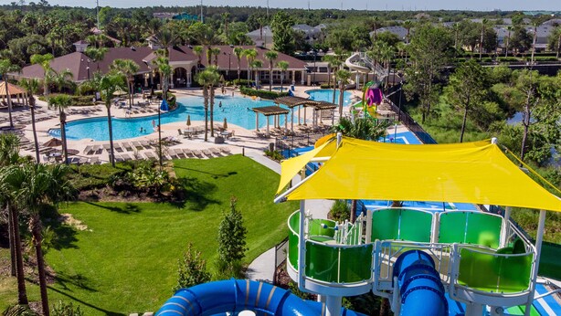 Un complexe hôtelier doté de plusieurs piscines, d’un toboggan aquatique et d’une pelouse bien entretenue.