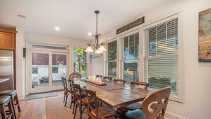 A dining area with a wooden table, chairs, and a chandelier.