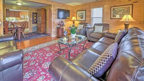 A cozy living room with leather sofas, a glass coffee table, and a red patterned rug. - 42 acres with Dramatic Mtn. Views...Close to Appalachian Trail (Bakersville)