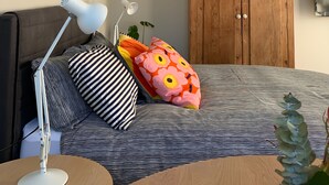 A bedroom with a bed, a desk with a lamp, a wardrobe, and a plant. - Inner city garden studio in the heart of Footscray (Footscray)