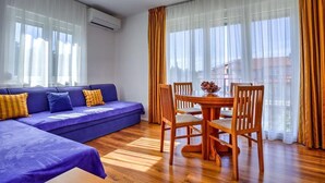 A modern living room with a blue sofa, wooden dining table, and chairs. - Villa DANEX KATORO 2 **** (Umag)