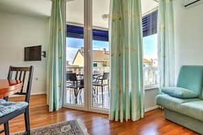 Relax on the balcony with a sliding glass door, featuring a dining area and comfortable seating.
