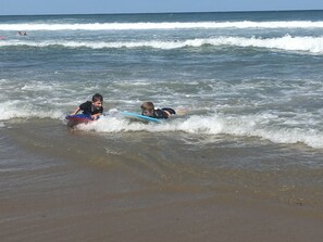 To børn på surfboards i havet.