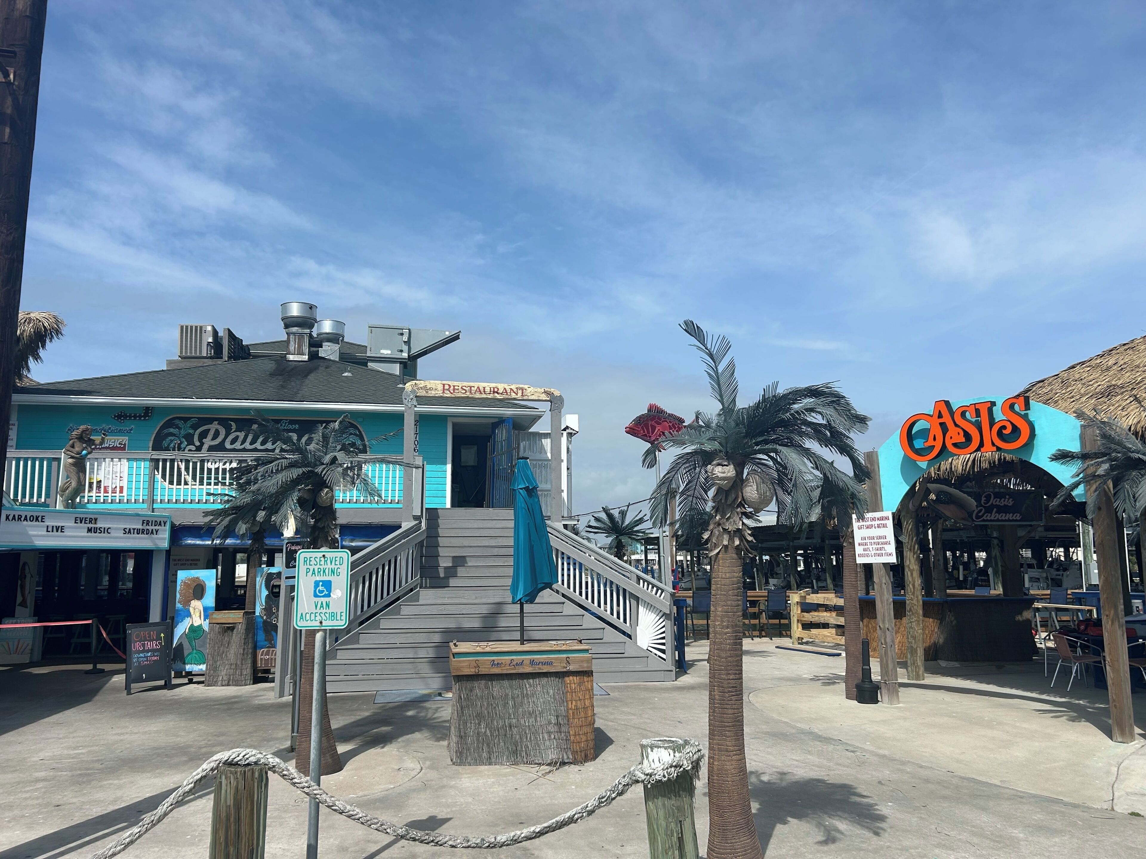 A beachfront restaurant with a sign for 'CASIS' and a 'KARATE' sign visible.