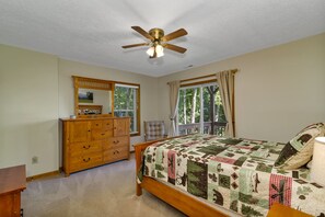 A bedroom with a wooden bed, a dresser, a ceiling fan, and a window with curtains. - 3 Master Suites - Long Mountain Views Every Room - Gated - Fire Pit - Fire Place (Maggie Valley)