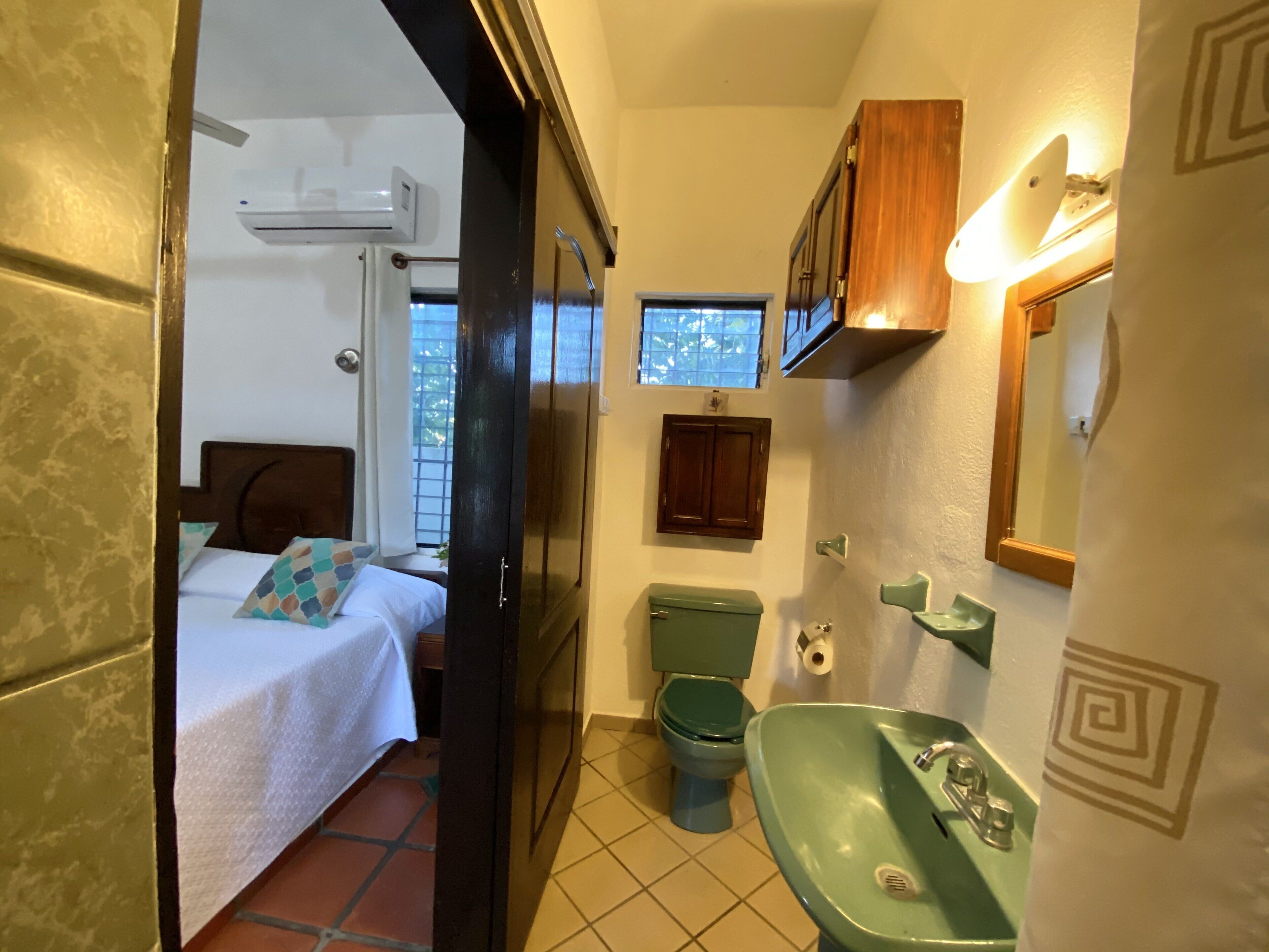 Un baño pequeño con inodoro, lavamanos y armario.