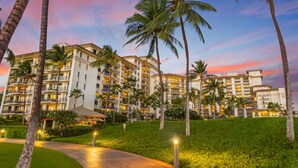 A multi-story hotel with balconies, surrounded by palm trees and well-maintained lawns. - Hale Nalani O-202 a hidden Gem,  comfort and fun  (Kapolei)