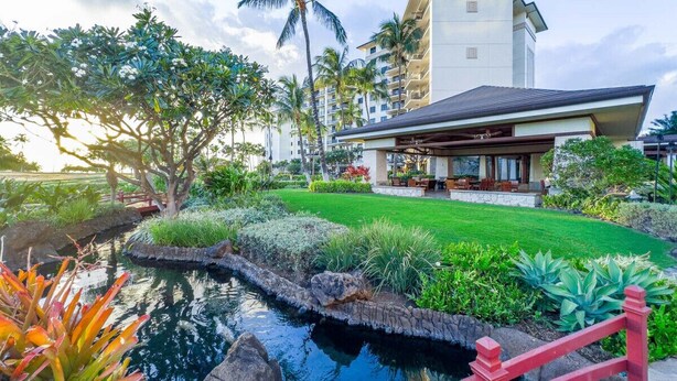A hotel with a pool, lush greenery, and a red bridge. - Hale Nalani O-202 a hidden Gem,  comfort and fun  (Kapolei)
