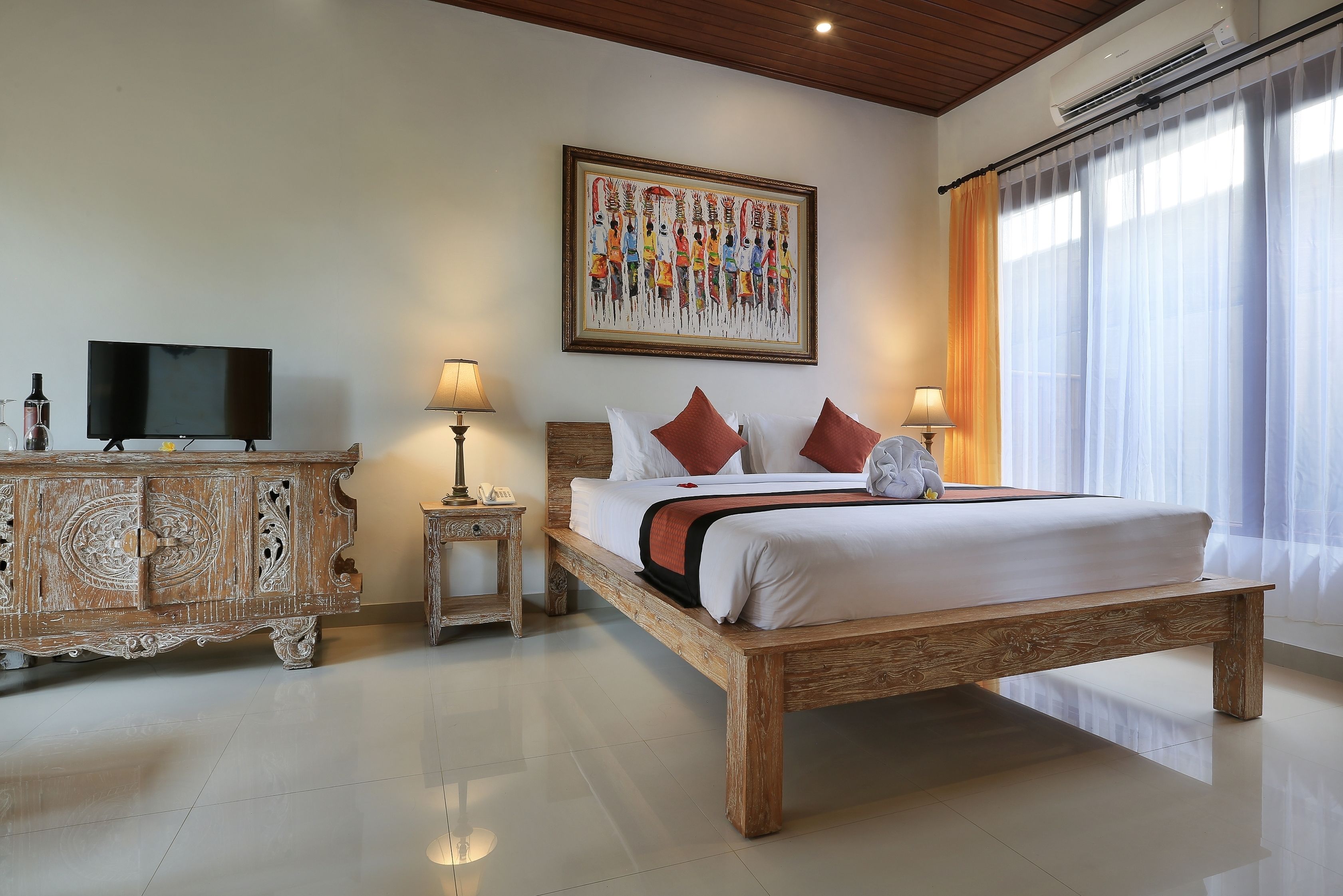 A bedroom with a wooden bed, a television, a cabinet, and a painting on the wall.