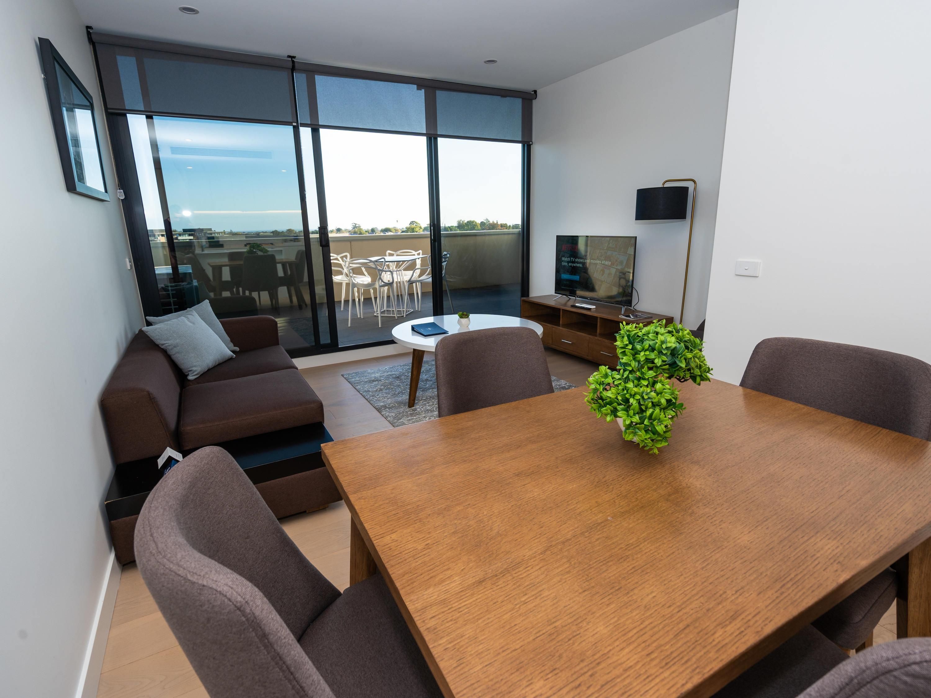 Una sala moderna con un sofá, una mesa de comedor y un televisor.