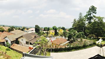 Een panoramisch uitzicht op een dorp met traditionele huizen, omgeven door groen en heuvels.