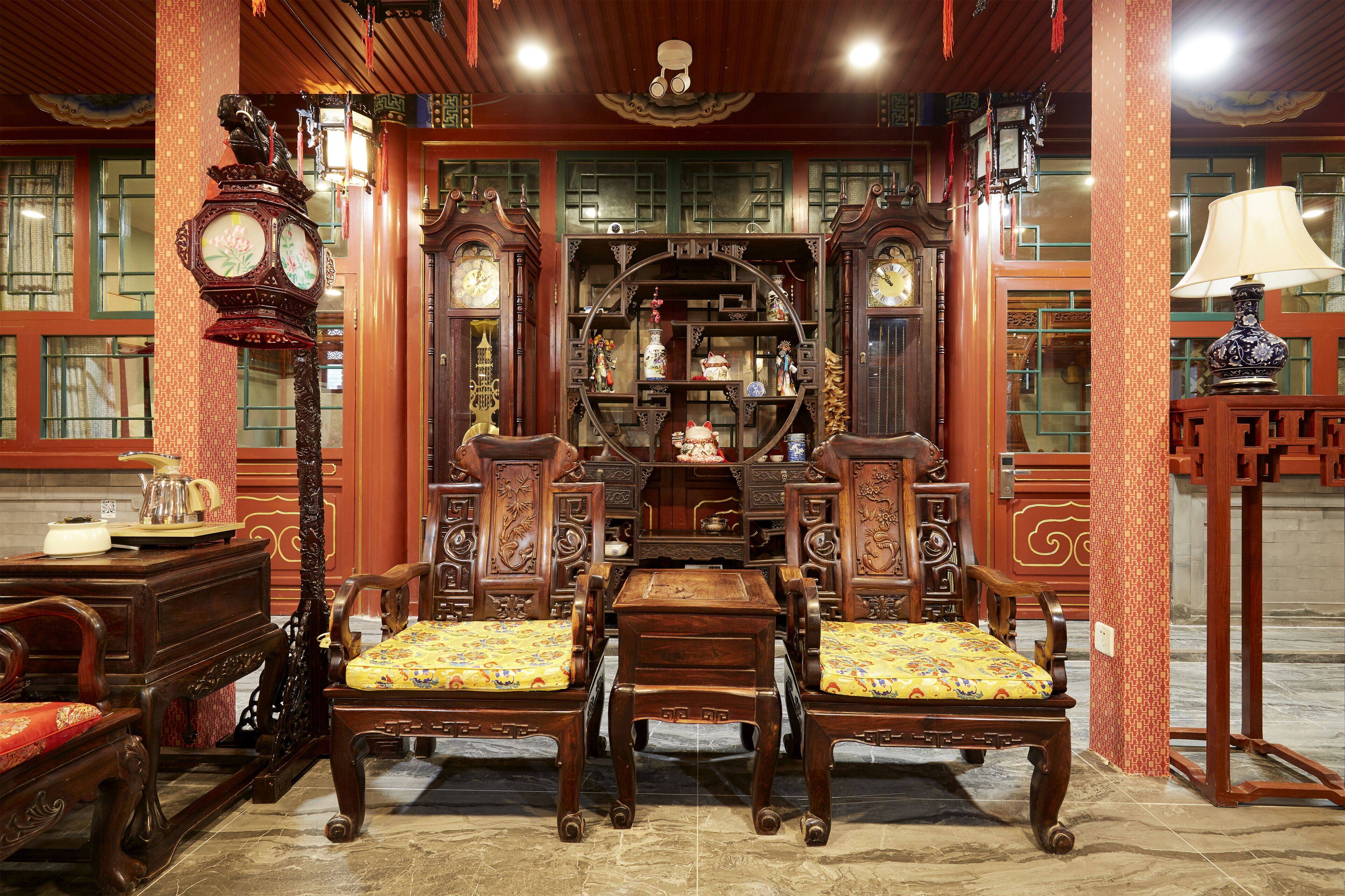 A traditional room with wooden furniture, including a sofa set and a table with chairs.