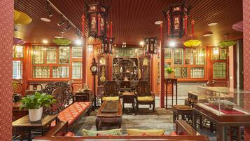 A traditional interior with wooden furniture, ornate decorations, and a central display case.