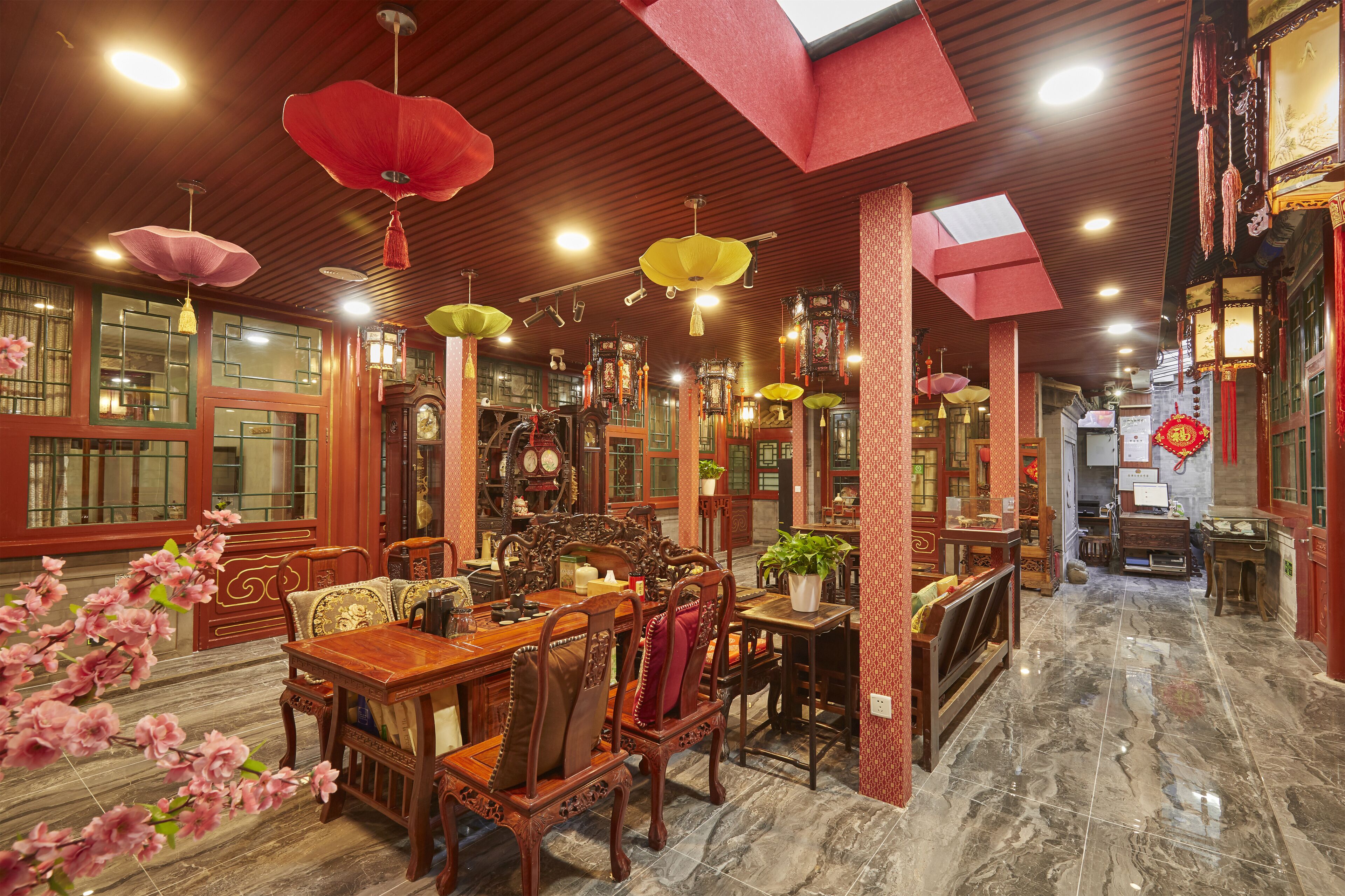 A traditional interior with wooden furniture, hanging lanterns, and a tiled floor.