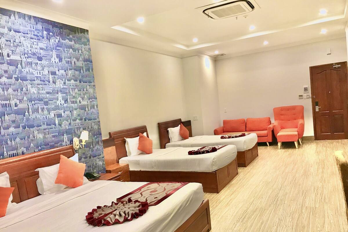 Habitación de hotel con dos camas, un sofá y una silla.