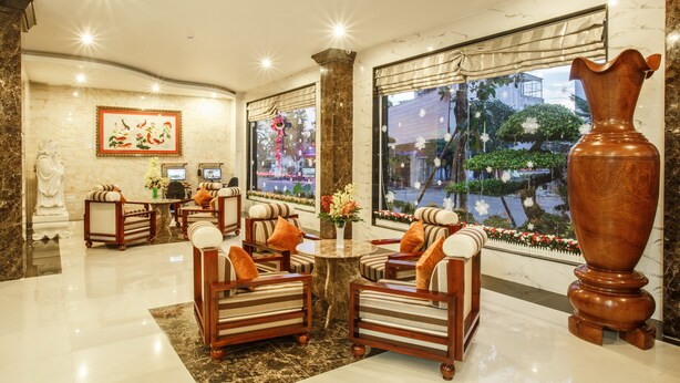 A lobby with a marble floor, wooden furniture, a large vase, and a painting on the wall. - Long Bao Chau Hotel (Ho Chi Minh City)