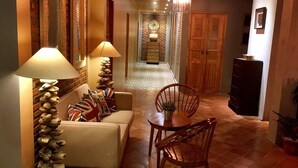 Un salon chaleureux avec un canapé, une table à manger et des chaises, ainsi qu’un mur décoratif en pierre.