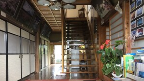 Ein Flur mit Schachbrettfußboden, Holzausbau und einer Treppe, die zu einem Raum führt.